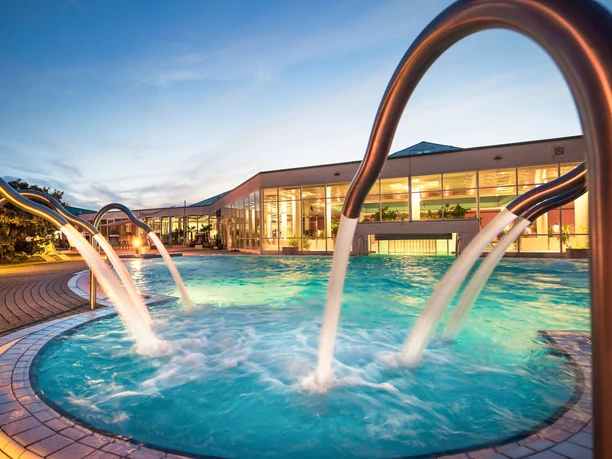 Badelandschaft des HEIDE SPA Bad Düben am Abend - Wellness in Leipzig und Region Der Außenbereich des HEIDE SPA in Bad Düben mit Pool wird zur Abenddämmerung beleuchtet, Wellness, Ausflug, Familie, Freizeit
