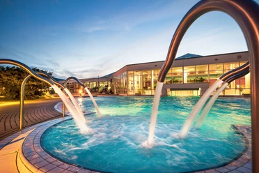 L'espace extérieur du HEIDE SPA à Bad Düben avec piscine s'illumine au crépuscule, bien-être, excursion, famille, loisirs
