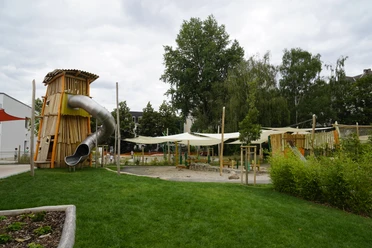 AbenteuerDorf Kids Campus - Familienurlaub in Leipzig Ein große Röhrenrutsche schlängelt sich aus dem hölzernen Turm des Abenteuerspielplatz.