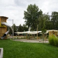 AbenteuerDorf Kids Campus - Familienurlaub in Leipzig Ein große Röhrenrutsche schlängelt sich aus dem hölzernen Turm des Abenteuerspielplatz.