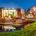 Kunsthalle-Emden_Foto-Bühler -141.jpg Außenansicht der Kunsthalle am Abend. Der Eingang liegt an einer breiten Treppe, im Hintergrund Bäume und Grachten.“Exterior view of the Kunsthalle in the evening. The entrance is on a wide staircase, with trees and canals in the background."Kunsthallen set udefra om aftenen. Indgangen er på en bred trappe med træer og kanaler i baggrunden."Buitenaanzicht van de Kunsthalle in de avond. De ingang is aan een brede trap, met bomen en grachten op de achtergrond."