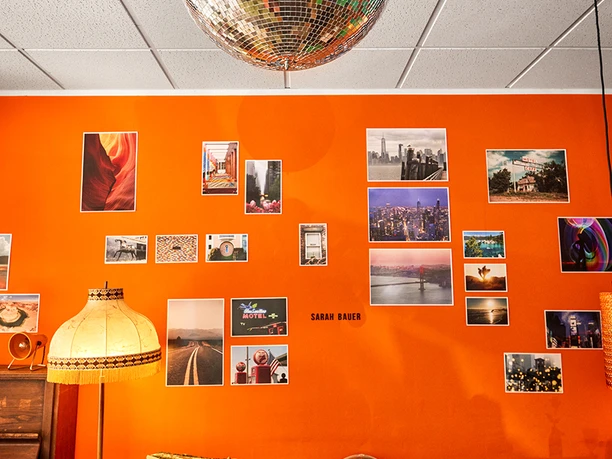 rosi, Gelsenkirchen Discokugel über orangefarbener Fotowand mit Sesseln im Café rosi in Gelsenkirchen