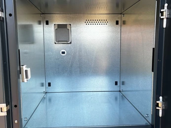 Fahrradschließfach Innenansicht Innenansicht eines offenen Fahrradschließfachs aus Metall mit Steckdose und Belüftungsöffnungen.