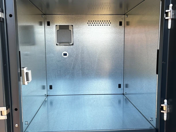 Fahrradschließfach Innenansicht Innenansicht eines offenen Fahrradschließfachs aus Metall mit Steckdose und Belüftungsöffnungen.