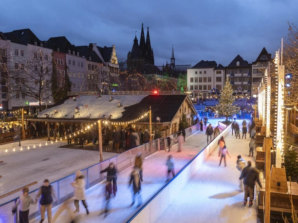 Heinzels Winter Fairytale A festively decorated ice rink on the Heumarkt in Cologne, surrounded by Christmas stalls and lights.