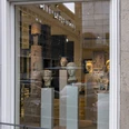 Belgisches Haus RGM In einem großen Fenster eines historischen Gebäudes sind mehrere antike Büsten und Skulpturen auf eleganten Sockeln ausgestellt. Die steinernen Kunstwerke variieren in Form und Größe, strahlen zeitlose Eleganz aus und werden durch eine helle Beleuchtung akzentuiert.In a large window of a historic building, several antique busts and sculptures are displayed on elegant pedestals. The stone works of art vary in shape and size, exude timeless elegance and are accentuated by bright lighting.