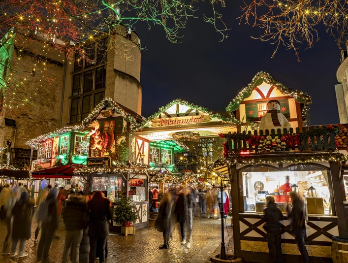 Nikolausdorf am Rudolfplatz Belebter Weihnachtsmarkt in Köln bei Nacht, geschmückte Hütten, bunte Lichter erhellen den Platz.Lively Christmas market in Cologne at night, decorated huts, colorful lights illuminate the square.