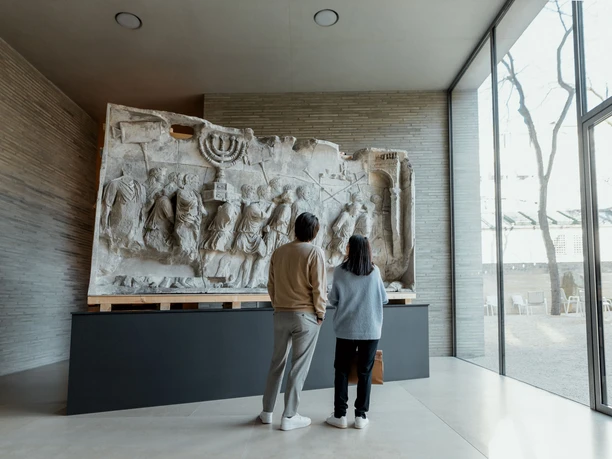 Kolumba In the Kolumba Museum in Cologne, two people look at a large, antique relief on a modern exhibition wall.