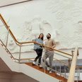 Museum Ludwig Das Bild zeigt zwei Personen, die eine Treppe im Museum Ludwig in Köln hinaufgehen, vor einer kunstvoll gestalten Wandgestaltung.The picture shows two people walking up a staircase in the Museum Ludwig in Cologne, in front of an artistically designed mural.