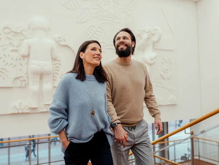 Museum Ludwig Ein Paar schreitet händchenhaltend eine breite Treppe im Museum Ludwig hinauf, umgeben von moderner Kunst an der Wand.A couple holding hands walks up a wide staircase in the Museum Ludwig, surrounded by modern art on the wall.