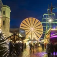 Cologne harbor Christmas market Weihnachtsmarkt bei Nacht mit einem großen, hell beleuchteten Riesenrad im Hintergrund und einem detailreichen, festlich geschmückten Piratenschiff im Vordergrund. Menschen schlendern über den beleuchteten Kopfsteinpflasterweg, umgeben von festlich dekorierten Verkaufsständen.Christmas market at night with a large, brightly lit Ferris wheel in the background and a detailed, festively decorated pirate ship in the foreground. People stroll along the illuminated cobblestone path, surrounded by festively decorated stalls.