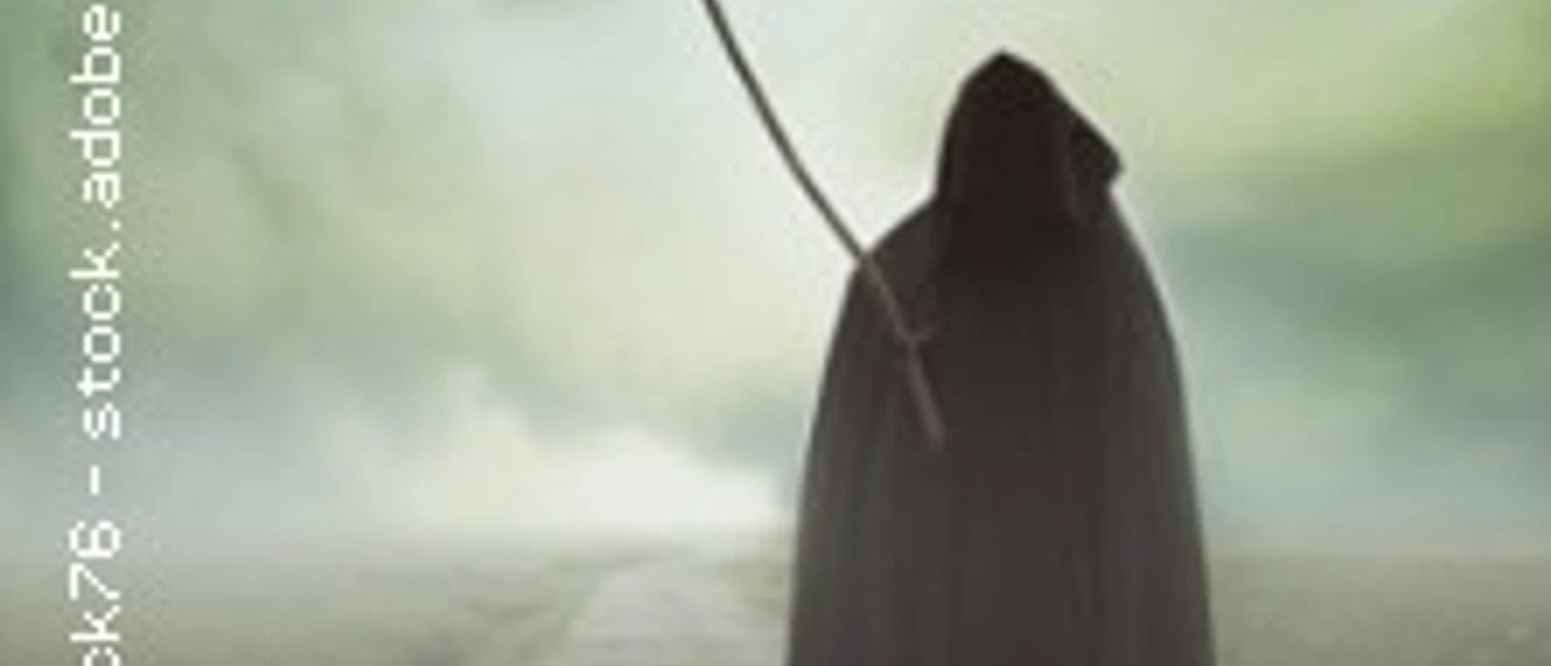 Ein vermummter Sensenmann steht auf einer einsamen Straße unter bewölktem Himmel, umgeben von Nebel.