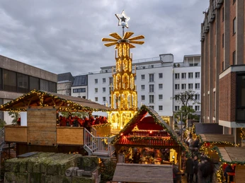Adventsdorf am Kölner Dom Eine hohe, beleuchtete Weihnachtspyramide mit Stern krönt das Adventsdorf am Kölner Weihnachtsmarkt.A tall, illuminated Christmas pyramid with a star crowns the Advent village at Cologne's Christmas market.
