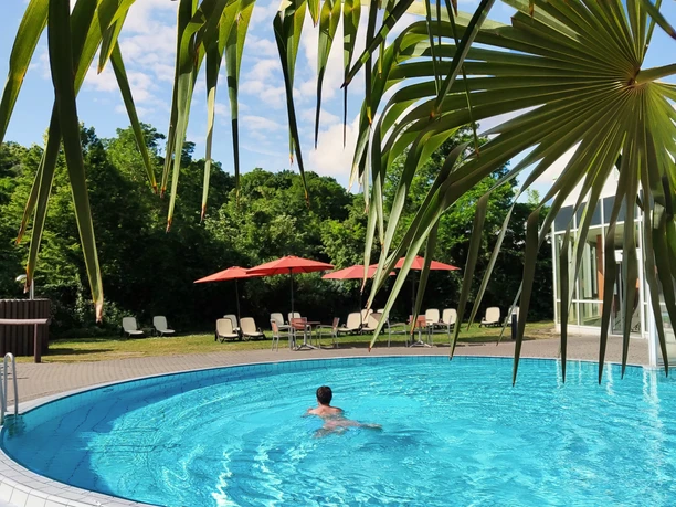 Saunawelt im HEIDE SPA Bad Düben - Wellness in Leipzig und Region Ein Mann schwimmt im Pool der Badelandschaft des Saunabereichs im Heide Spa Bad Düben bei sonnigem Wetter, Ausflug, Wellness, Freizeit