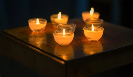 candles-kerzen-2138132_1920_pixabay.jpg Nahaufnahme von sieben kleinen, leuchtenen Kerzen in dunkeln.