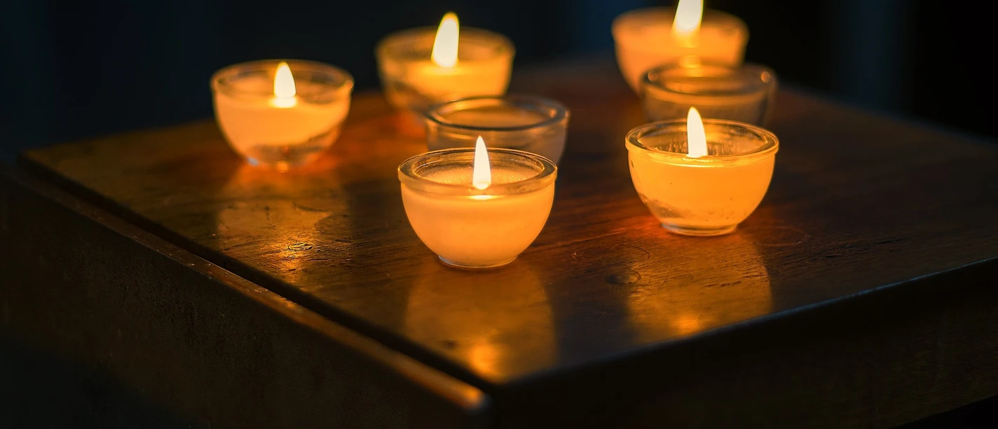 candles-kerzen-2138132_1920_pixabay.jpg Nahaufnahme von sieben kleinen, leuchtenen Kerzen in dunkeln.