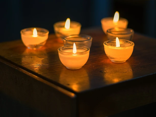 candles-kerzen-2138132_1920_pixabay.jpg Nahaufnahme von sieben kleinen, leuchtenen Kerzen in dunkeln.