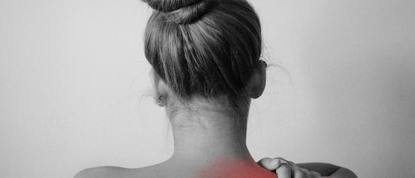 Vortrag Schulterschmerzen Eine Frau von hinten mit einem roten Bereich am Nacken, der auf Schmerzen hinweist.