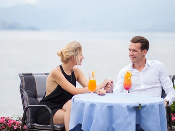 Beau Rivage Restaurant Paar sitzt am Tisch im Garten des Beau RivagesCouple sitting at the table in the garden of the Beau RivagesCouple assis à table dans le jardin du Beau Rivages