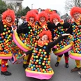 KVE_9254.JPG Menschen in bunten Kostümen mit roten Perücken und aufgeblasenen Ringen feiern ausgelassen Karneval.