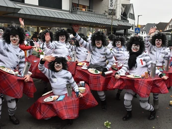 KVE_9318.JPG Gruppe von kostümierten Karnevalsteilnehmern in rot-weißen Kostümen, mit fröhlich erhobenen Armen.