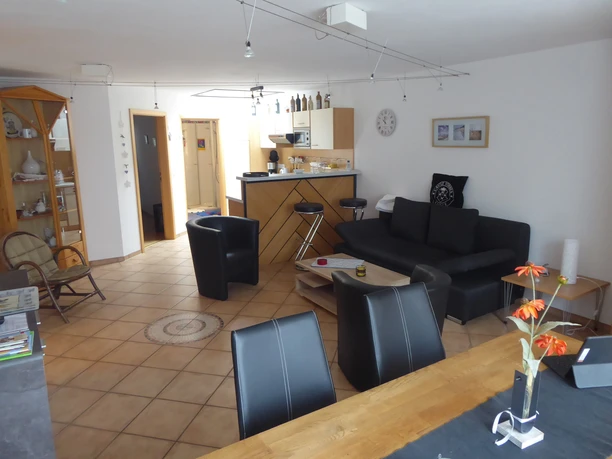 Fewo Strakeljahn Wohnzimmer Gemütliches Wohnzimmer mit Holzmöbeln, Essbereich und offener Küche in einer harmonischen Atmosphäre.