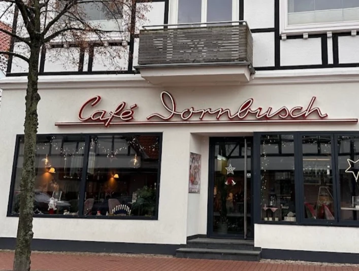 Außenansicht Fachwerkgebäude mit Café Dornbusch, breite Fensterfront, Leuchtreklame und großer Eistüte außen.Half-timbered building with Café Dornbusch, wide window front, neon sign and large ice cream cone outside.Bindingsværksbygning med Café Dornbusch, bred vinduesfront, neonskilt og stor isvaffel udenfor.Vakwerkgebouw met Café Dornbusch, brede raamgevel, neonreclame en grote ijshoorn buiten.