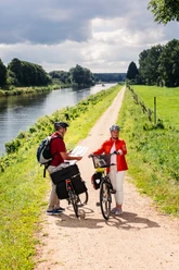 Radfahrer auf der Techniktour Zwei Personen stehen mit ihren Fahrrädern auf dem Radweg.