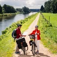 Radfahrer auf der Techniktour Zwei Personen stehen mit ihren Fahrrädern auf dem Radweg.