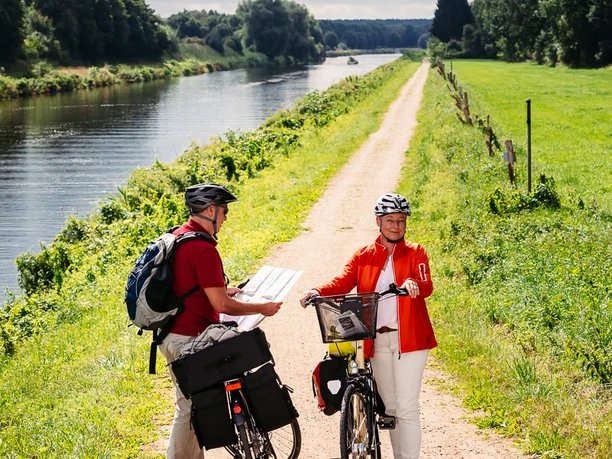 Radfahrer auf der Techniktour Zwei Personen stehen mit ihren Fahrrädern auf dem Radweg.