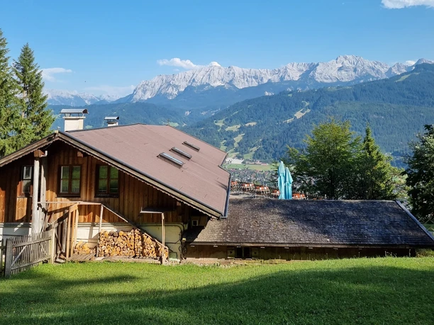 St. Martins Hütte im Sommer Holzhütte auf Wiese vor weitem Alpenpanorama mit Blick auf Berge und Tal im Sommer