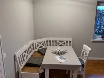 holsing 5.jpg Eckbank mit Holztisch und gemütlichen Stühlen in modernem Esszimmer bei Tageslicht.