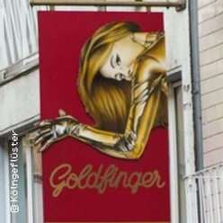 Ein auffälliges, rotes Schild mit einer goldenen Frau und dem Text "Goldfinger" in geschwungener Schrift.