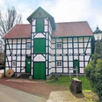 Gutswassermühle Bad Holzhausen Fachwerkgebäude der Gutswassermühle Bad Holzhausen, umgeben von Bäumen und parkendem Auto.