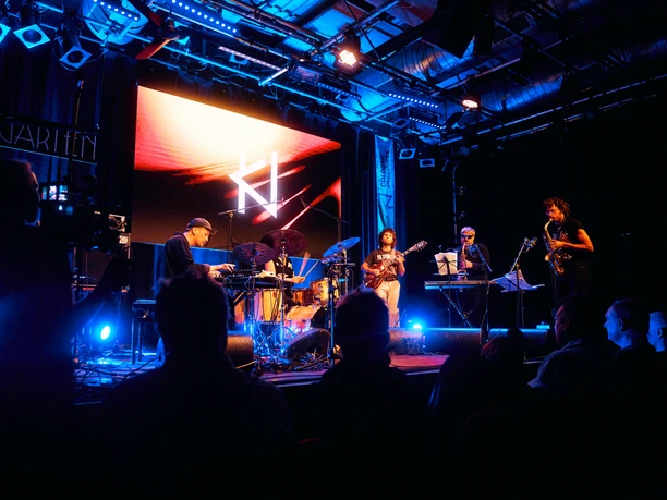Cologne Jazzweek Musik-Ensemble spielt auf erleuchteter Bühne bei der Cologne Jazzweek vor fasziniertem Publikum.