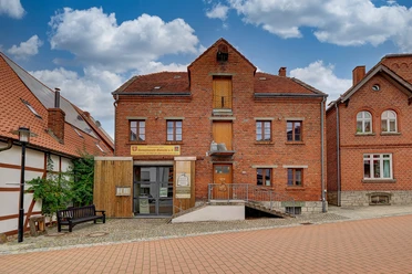 Sackmuseum Backsteingebäude des Sackmuseums mit Rampe, umgeben von gepflasterter Straße und Nachbarhäusern.