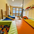 Kinderkrippe-Amelinghausen-22.jpg Heller Bewegungsraum einer Kinderkrippe mit Bällebad, Matten und Klettergeräten zum Spielen.