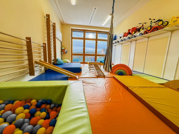 Kinderkrippe-Amelinghausen-22.jpg Heller Bewegungsraum einer Kinderkrippe mit Bällebad, Matten und Klettergeräten zum Spielen.
