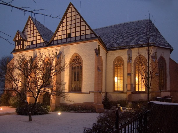 Klosterkirche_Blomberg_cr_Rüdiger Haase.jpg Beleuchtete Klosterkirche in Blomberg bei Dämmerung mit schneebedecktem Dach und gotischen Fenstern.