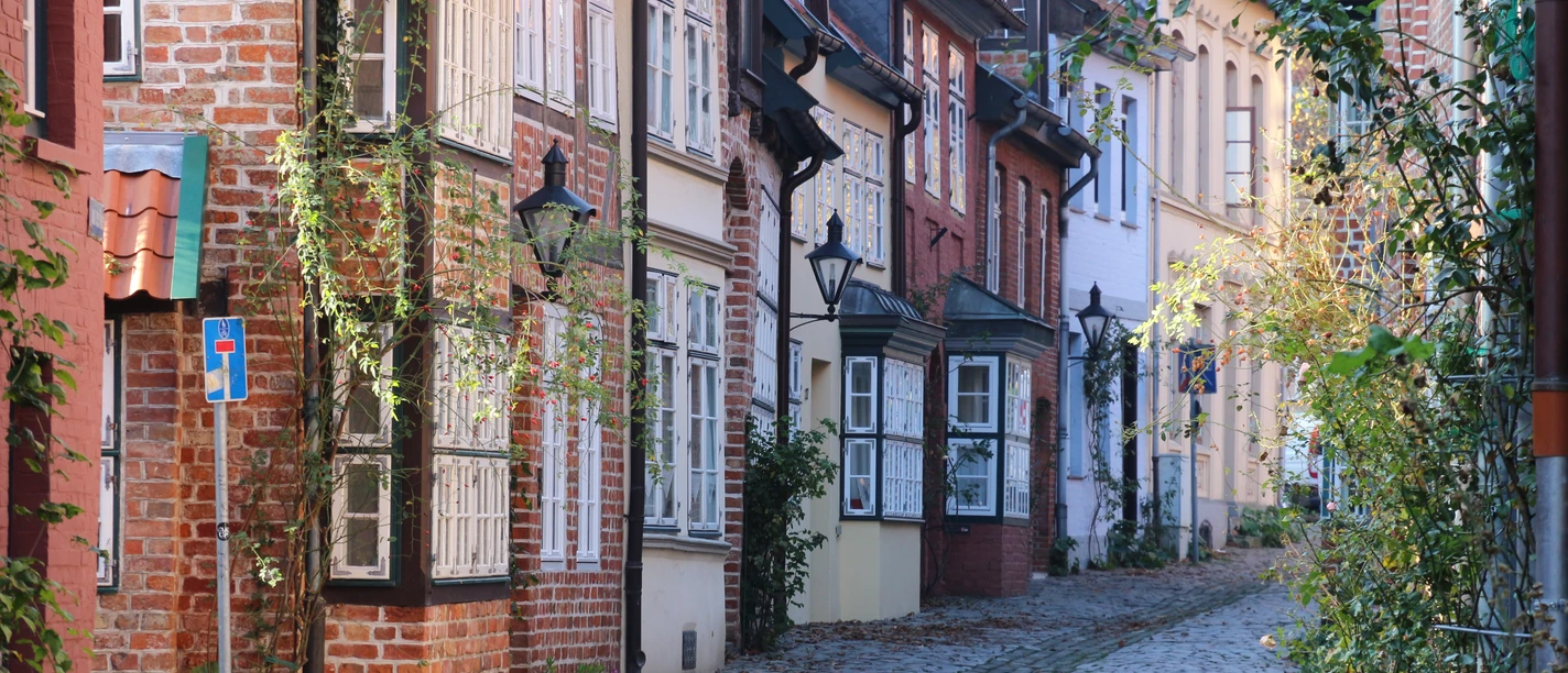 Kopfsteinpflastergasse in der westlichen Altstadt mit historischen Backstein- und Fachwerkhäusern in Lüneburg.
