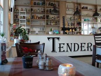 Innengastronomie Café Tender Gemütliches Café-Interieur mit Holzmöbeln, liebevoller Dekoration und einer gut bestückten Theke.