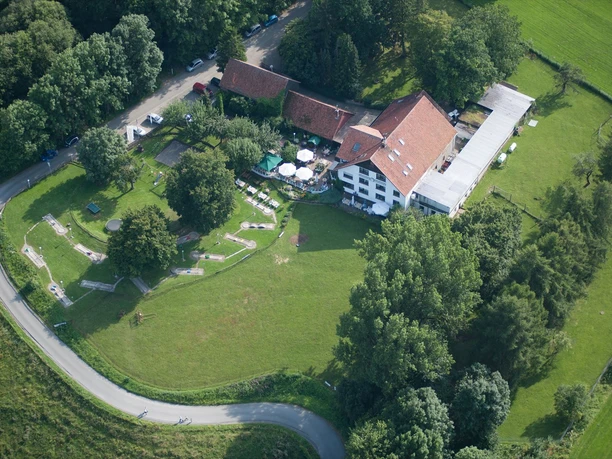 Luftansicht des Kempenhofs mit roten Dächern, umgeben von Wiesen und Bäumen in Lügde.