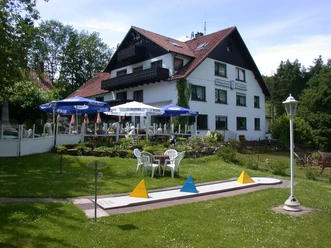 Außenansicht Kempenhof Der Kempenhof, ein mehrstöckiges Gebäude mit roten Dächern, umgeben von einer grünen Gartenanlage.