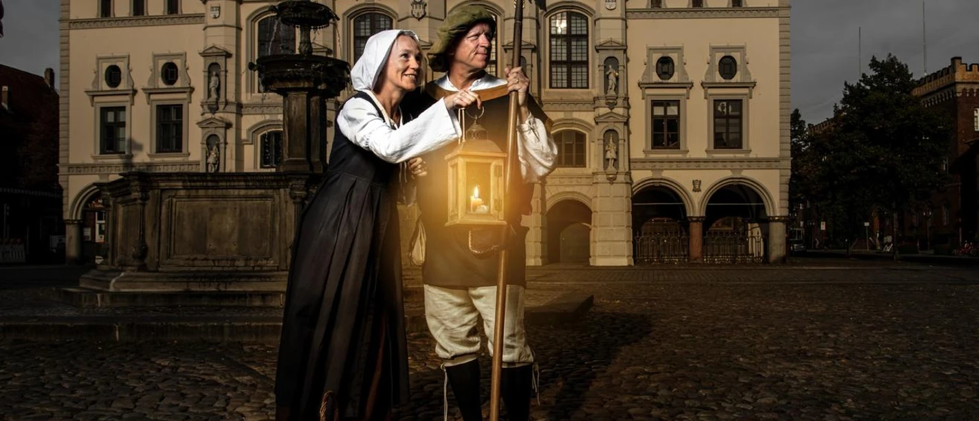 Durch_die_Nacht_mit_Claas_und_Trine.jpg Claas und Trine in historischen Kostümen mit Laterne und Hellebarde vor dem Rathaus Lüneburg.