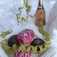 Karneval im Schnee Eine Platte mit Donuts und Sektflasche, dekoriert mit bunten Luftschlangen im Schnee.