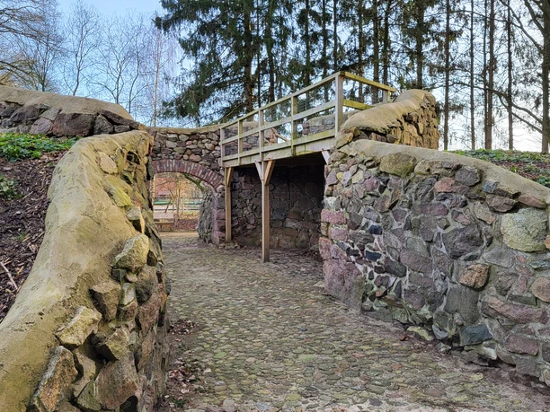 Ruine Windmühle Bruneforth, Stavern ©Naturpark Hümmling (3).jpg Steinruine einer historischen Windmühle mit Rundbogen und Holzplattform im Naturpark Hümmling.