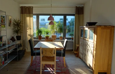 Ferienwohnung Jakobs Essbereich Essbereich mit Holzstühlen und Tisch, Sonnenlicht vom Fenster, Pflanzen auf Fensterbank.