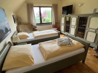 View into a cozy and rustic furnished bedroom with two single beds.