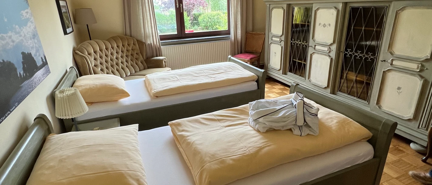 Schlafzimmer in Gretes Hof View into a cozy and rustic furnished bedroom with two single beds.