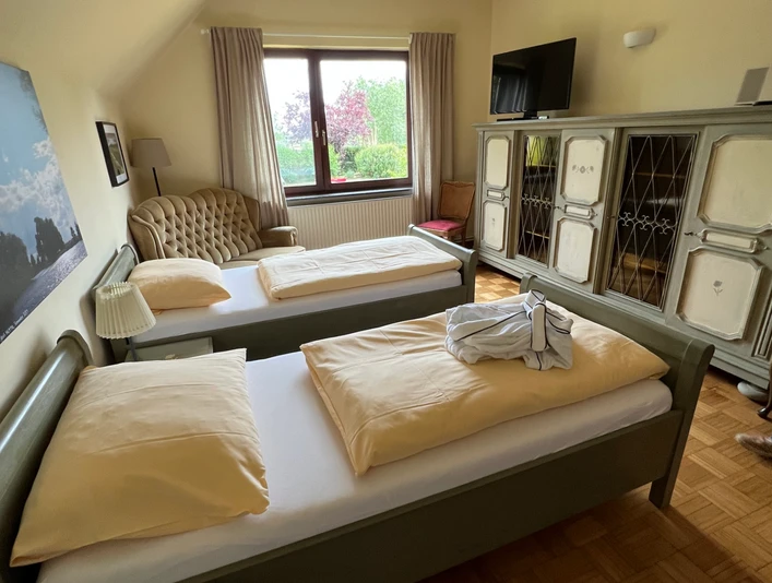 Schlafzimmer in Gretes Hof Blick in ein gemütlich und rustikal eingerichtetet Schlafzimmer mit zwei Einzelbetten.View into a cozy and rustic furnished bedroom with two single beds.Udsigt til et hyggeligt og rustikt indrettet soveværelse med to enkeltsenge.Uitzicht in een gezellige en rustiek ingerichte slaapkamer met twee eenpersoonsbedden.